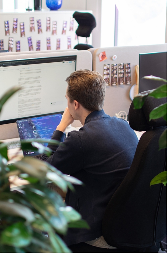 En utvecklare på qte sitter och jobbar vid sitt skrivbord.